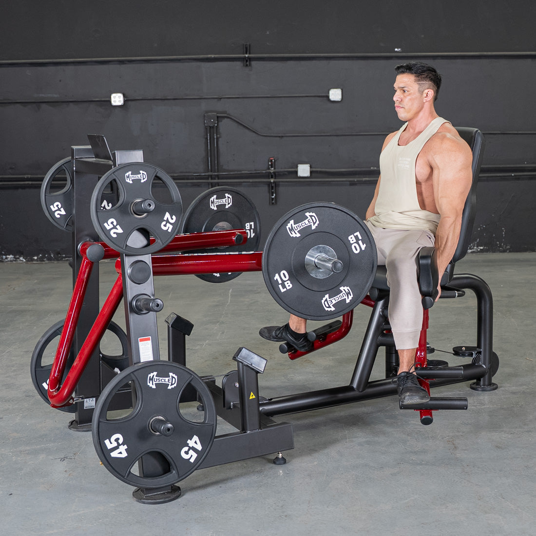 Fitness man seated on Power Leverage Abductor/Adductor machine with plates.