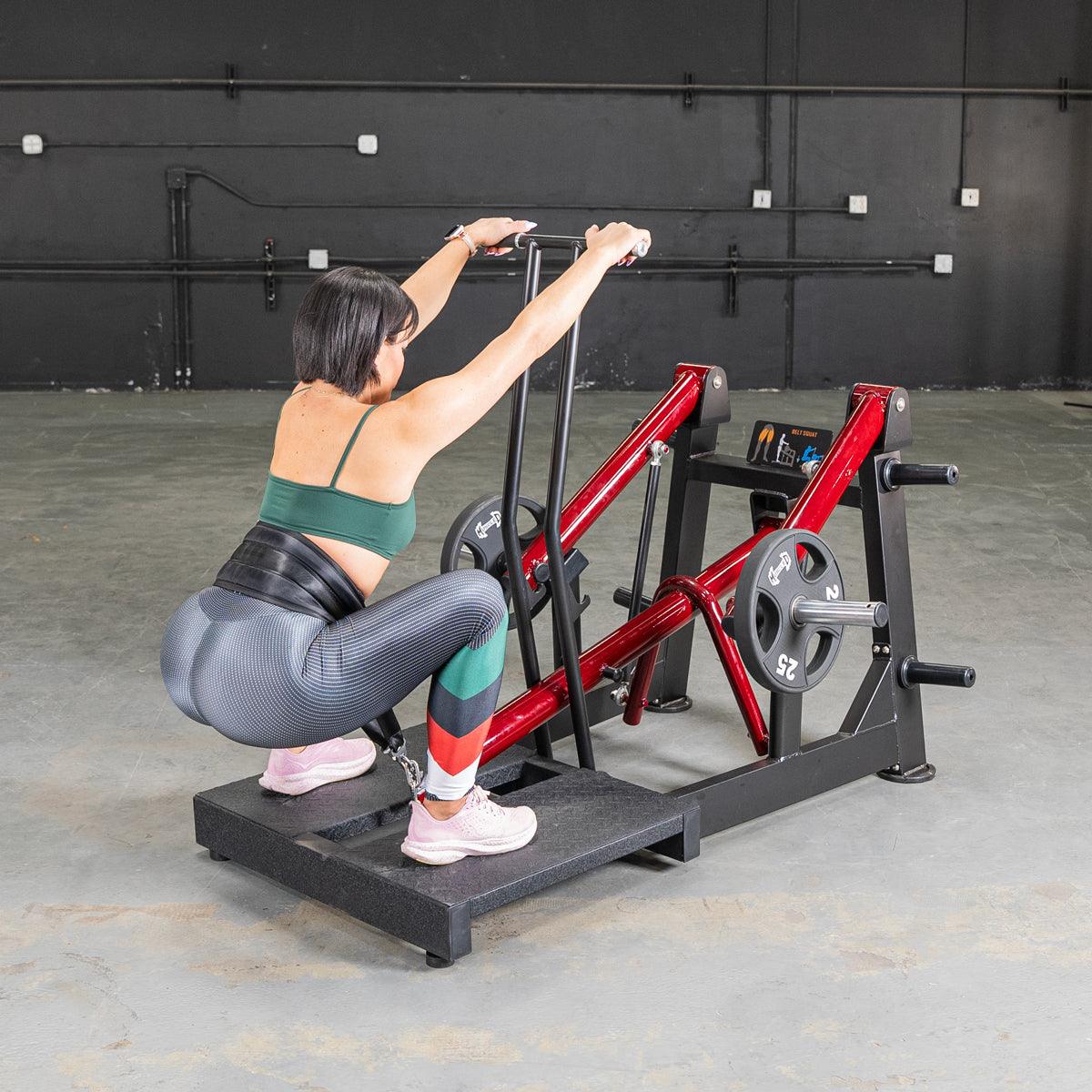 Woman performing a belt squat on a Power Leverage V2 machine in the gym.