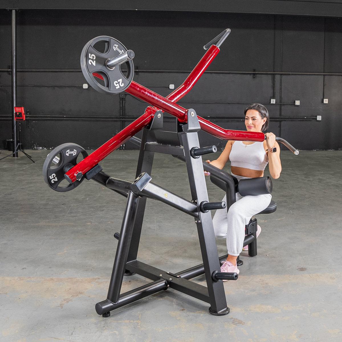 Woman using red seated row machine in gym for strength training.