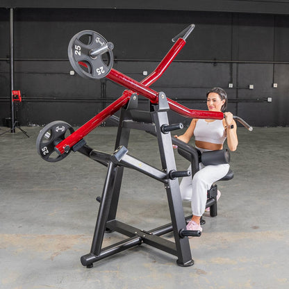Woman using red seated row machine in gym for strength training.