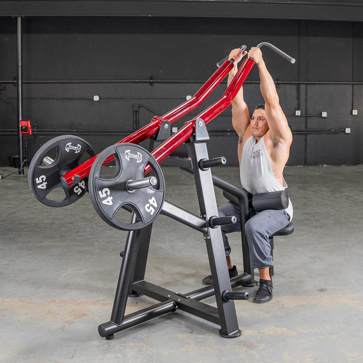 Man using Muscle D Fitness triceps machine with red handles in gym.