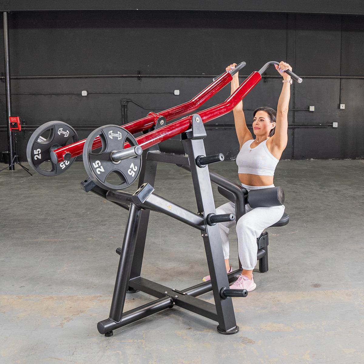 Woman using red seated row machine with weights in gym.