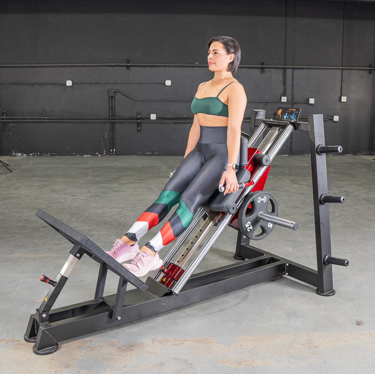Woman on a power-leverage hack squat machine in a gym.