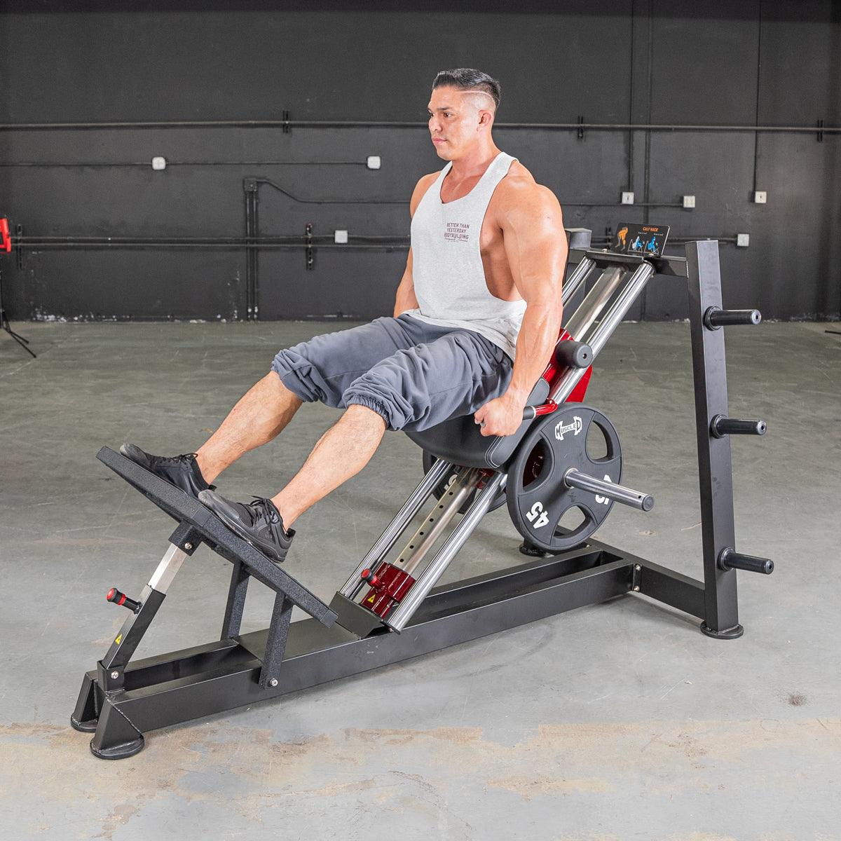 Man using a power-leverage hack squat machine for leg workout.