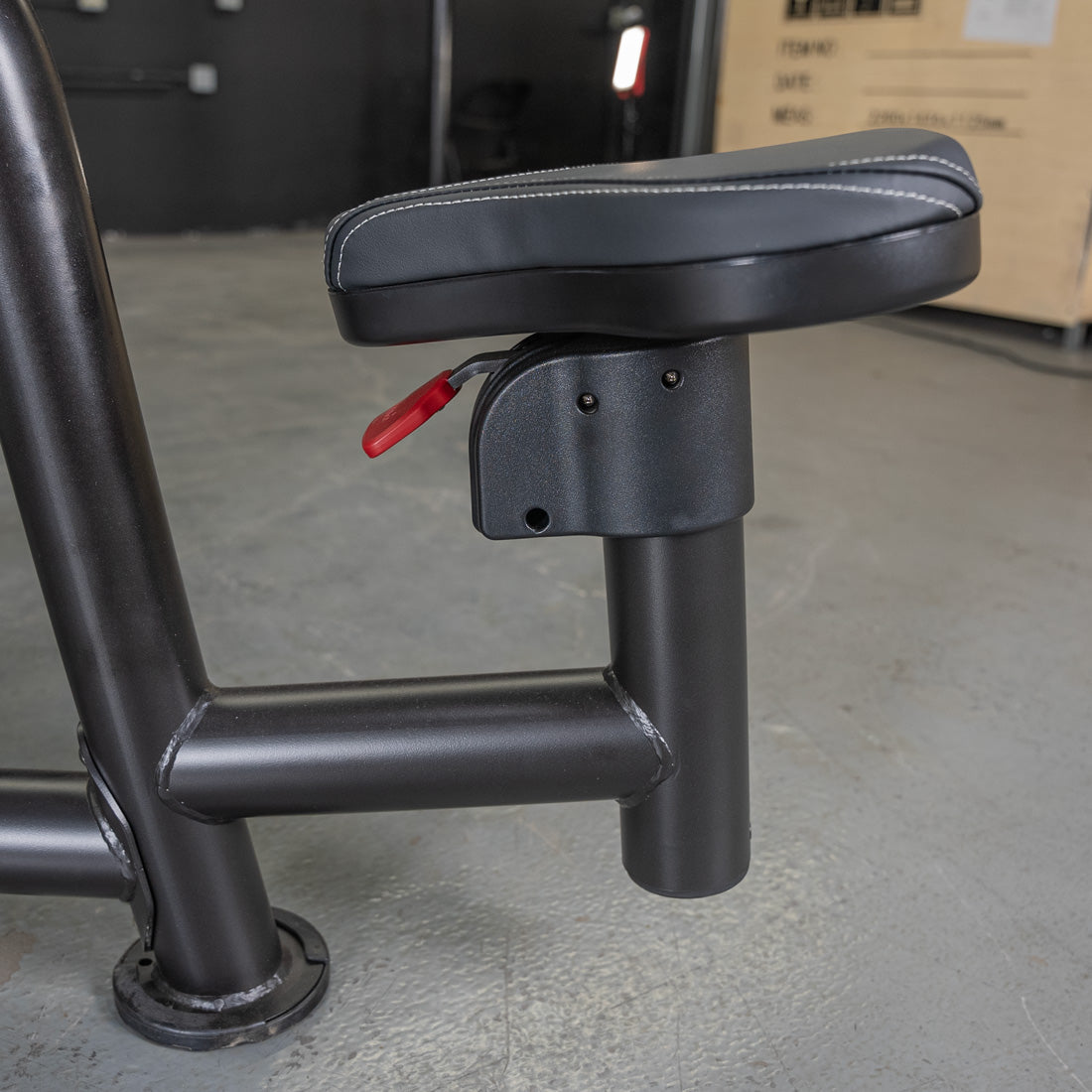 Black adjustable weight bench seat with red adjustment lever.