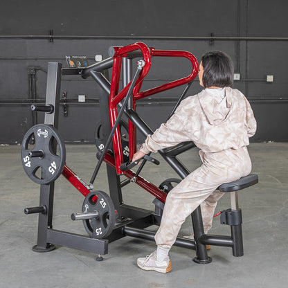 Woman using a red plate-loaded row machine in a gym.