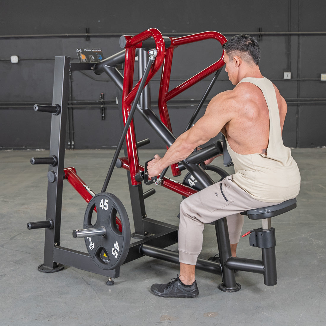 Man using Body-Solid leverage row machine with red frame for back workout.