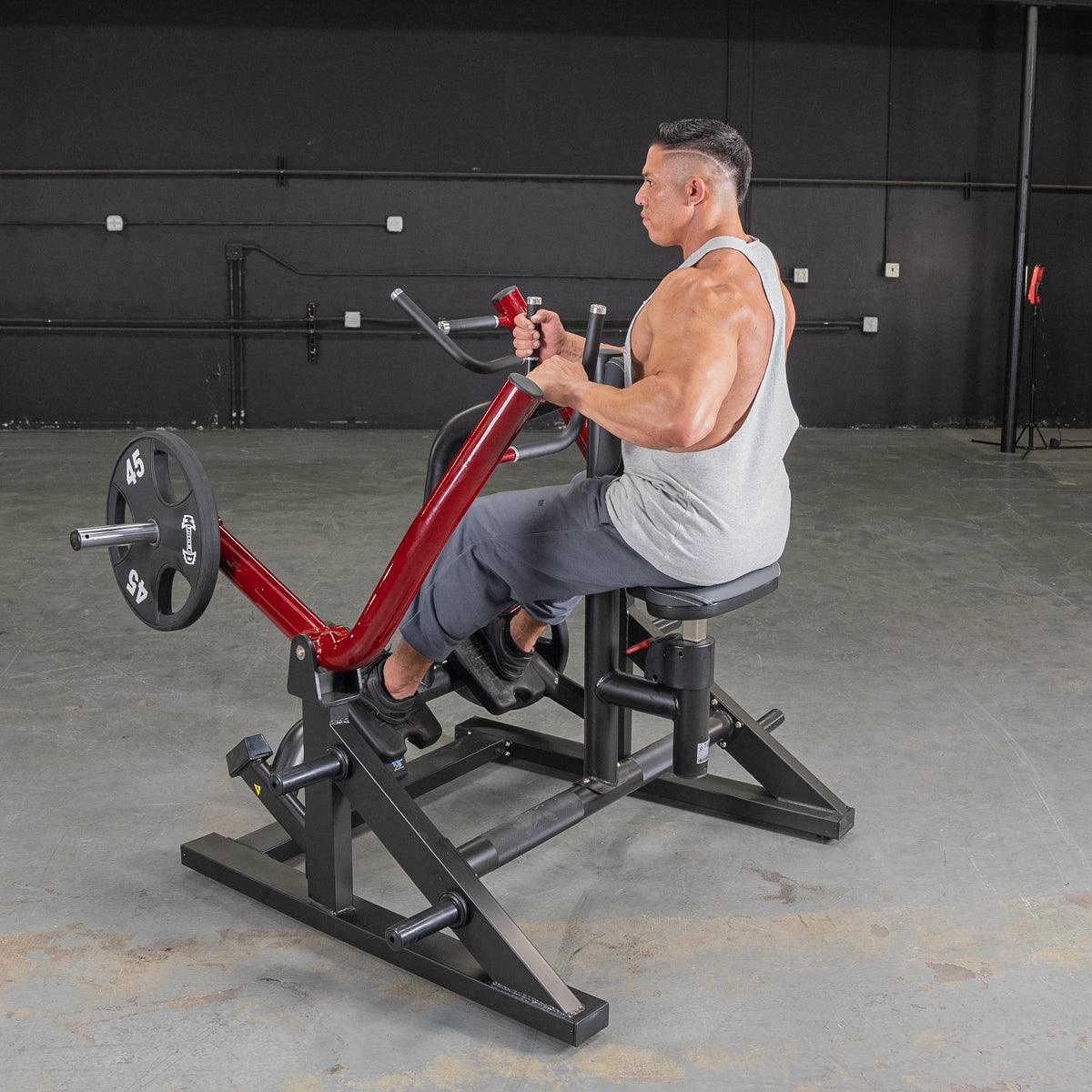 Man using a red seated row machine in a gym for back exercises.