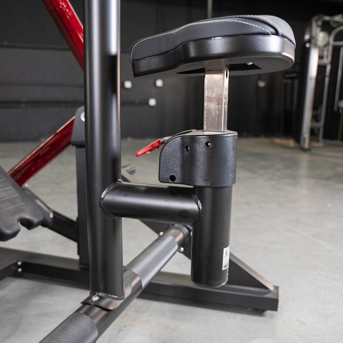 Adjustable seat mechanism on black gym equipment with red accents.