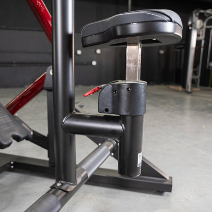Adjustable seat mechanism on black gym equipment with red accents.