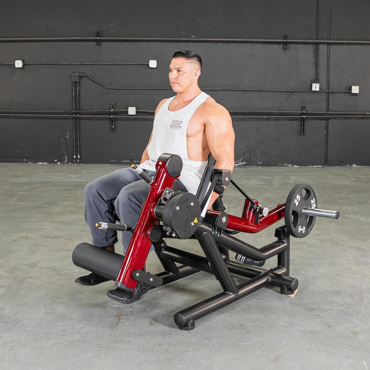 Man seated on Power Leverage V2 leg extension-prone leg curl machine.