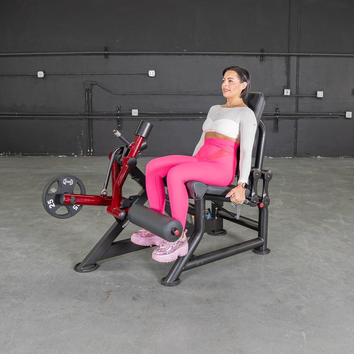 Woman on Power Leverage V2 Leg Extension machine at the gym.
