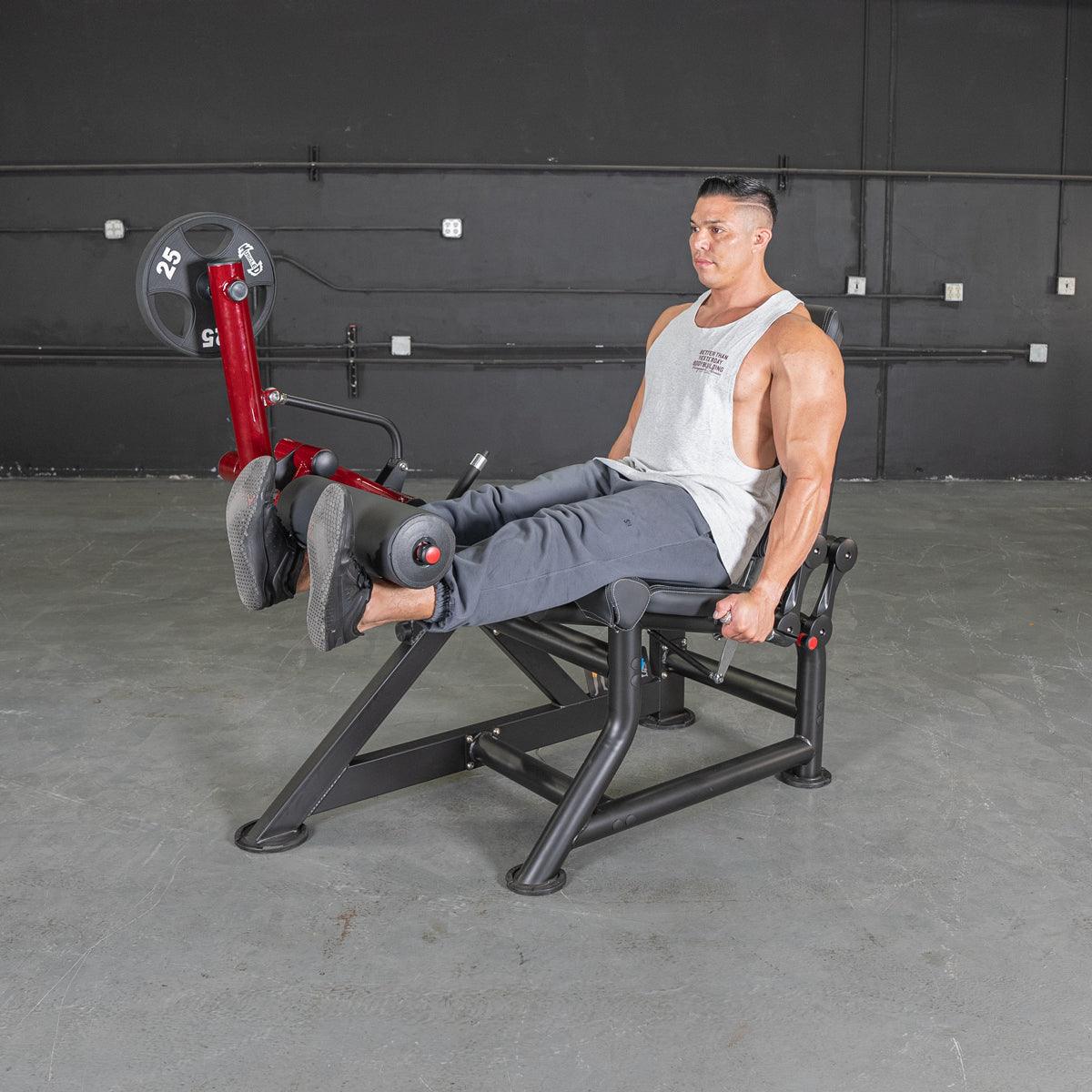 Man performing leg extension on Power Leverage V2 machine in gym