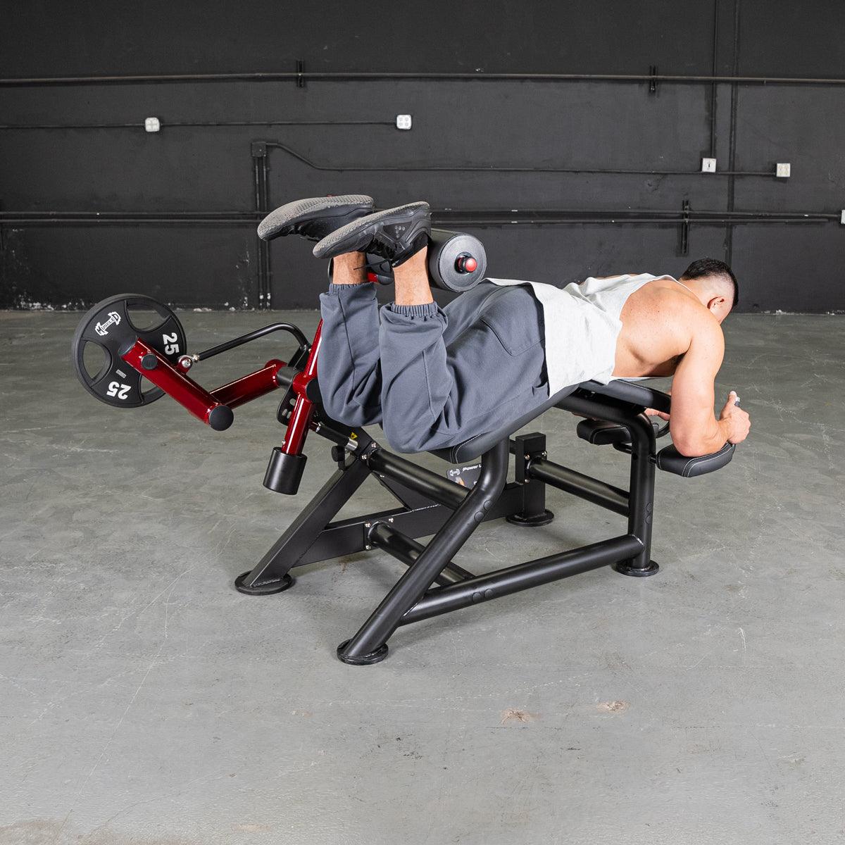 Person lying prone on a Power Leverage V2 Prone Leg Curl machine.