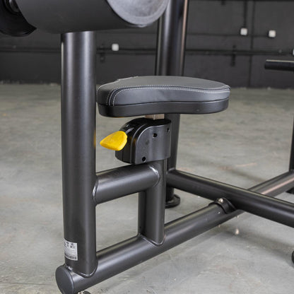 Adjustable black gym machine seat with yellow lever for easy customization.