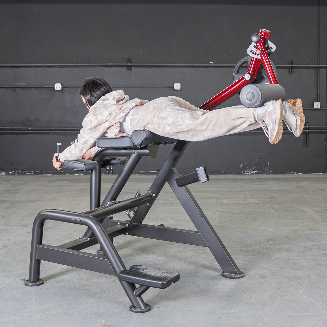 Person using Power Leverage V2 Reverse Hyper machine in gym.