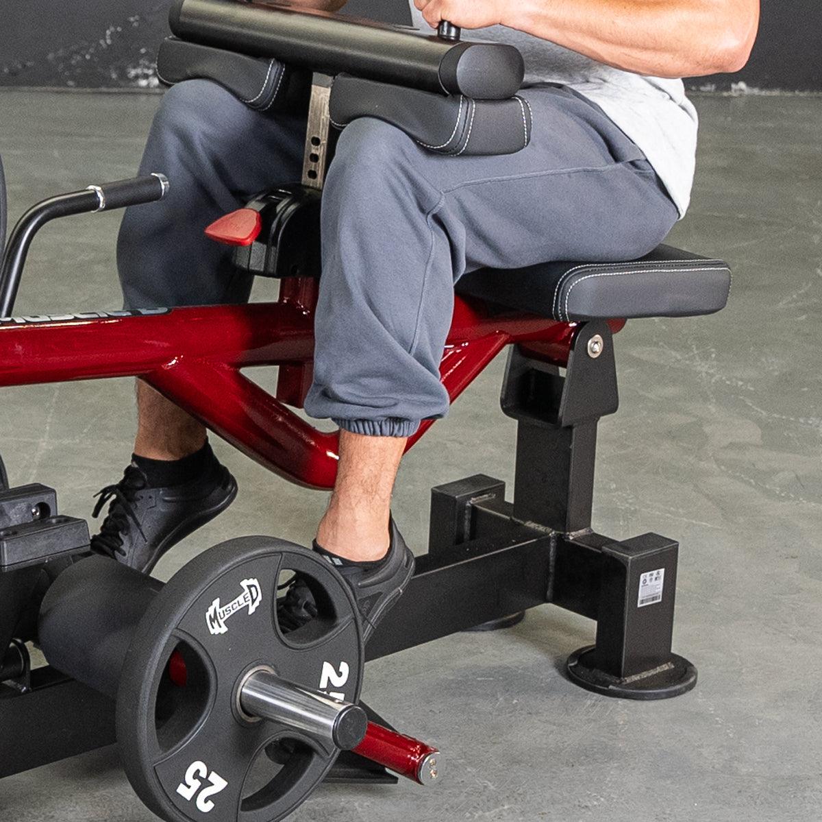 Person seated on a calf-raise machine, performing seated calf raises.