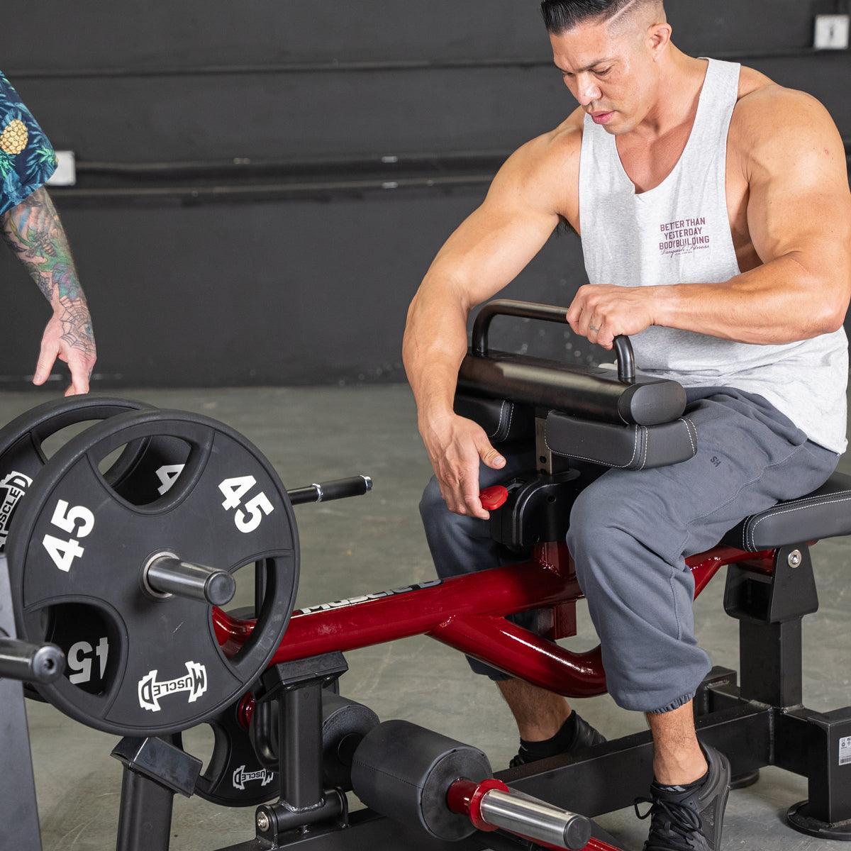 Man on Power Leverage seated calf raise machine with 45 lb plates.