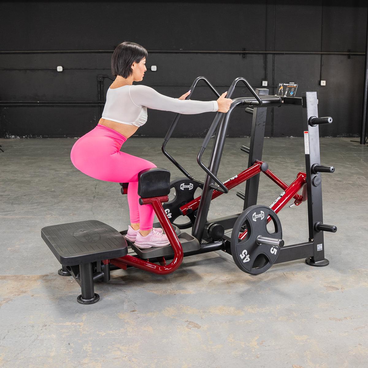 Woman using Power Leverage V2 standing abductor machine in gym.