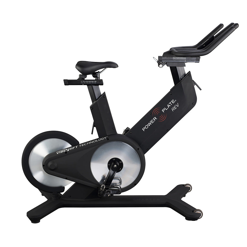 Power Plate REV exercise bike featuring VibeShift technology, designed for indoor cycling workouts, with a sleek black frame and adjustable seat.