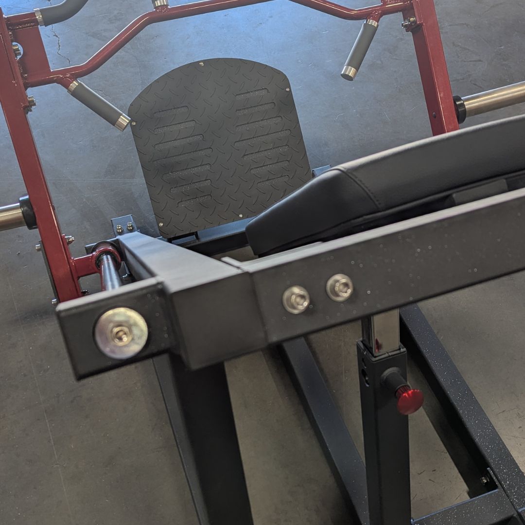 Close-up of a Power Leverage V2 Linear Bearing Row gym machine with red and black frame on a concrete floor.