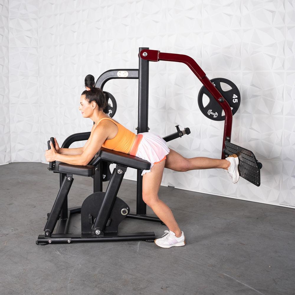 Woman on Pro Strength Booty Shaper machine performing glute bridge exercise.