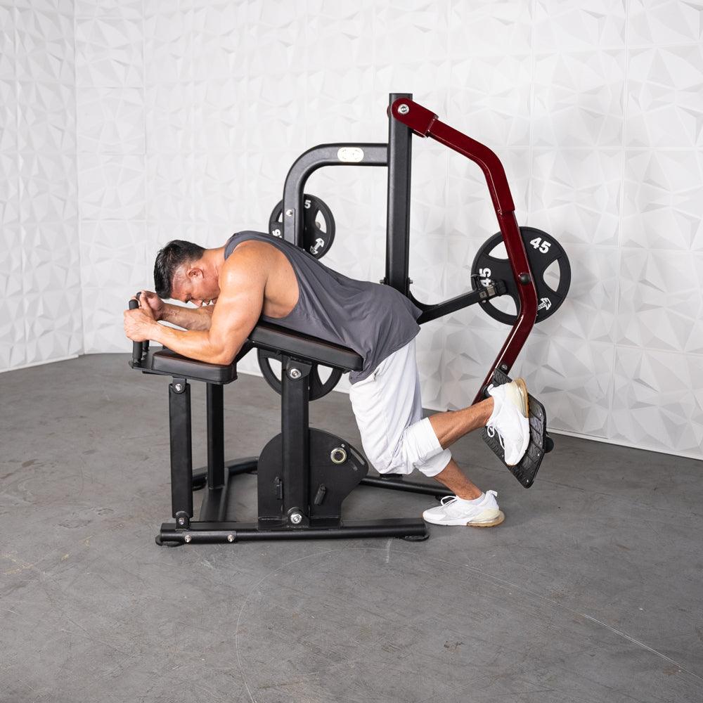 Man using Pro-Strength Booty Shaper machine for glute workout with weights.