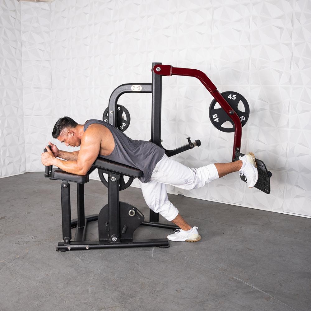 Man using Pro-Strength Booty Shaper gym machine for hip extension.