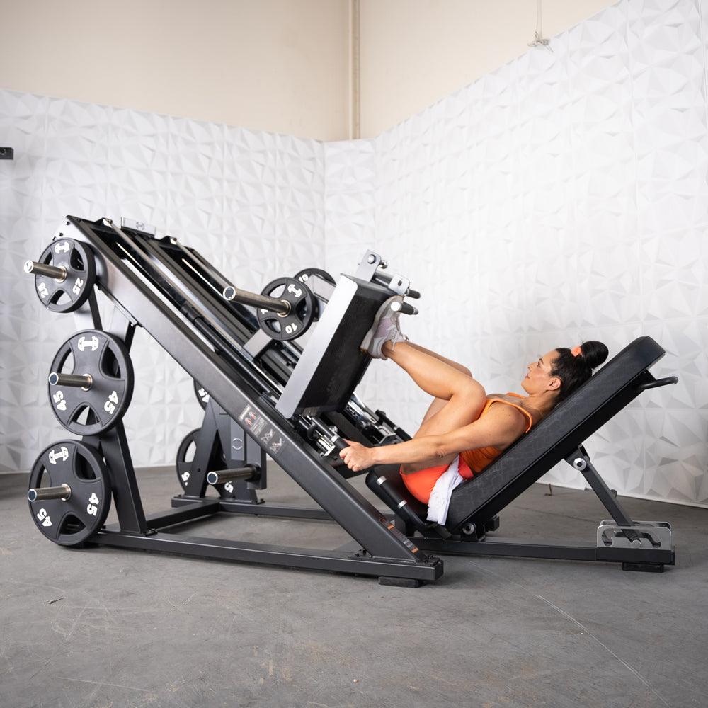Woman on ProStrength dual leg press machine in gym.