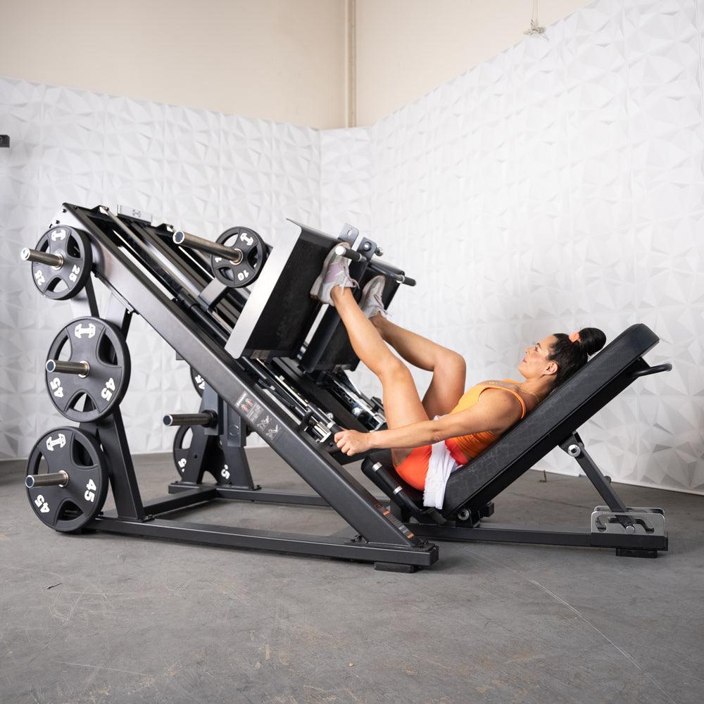 Woman performing leg press on ProStrength dual-leg press machine in gym.