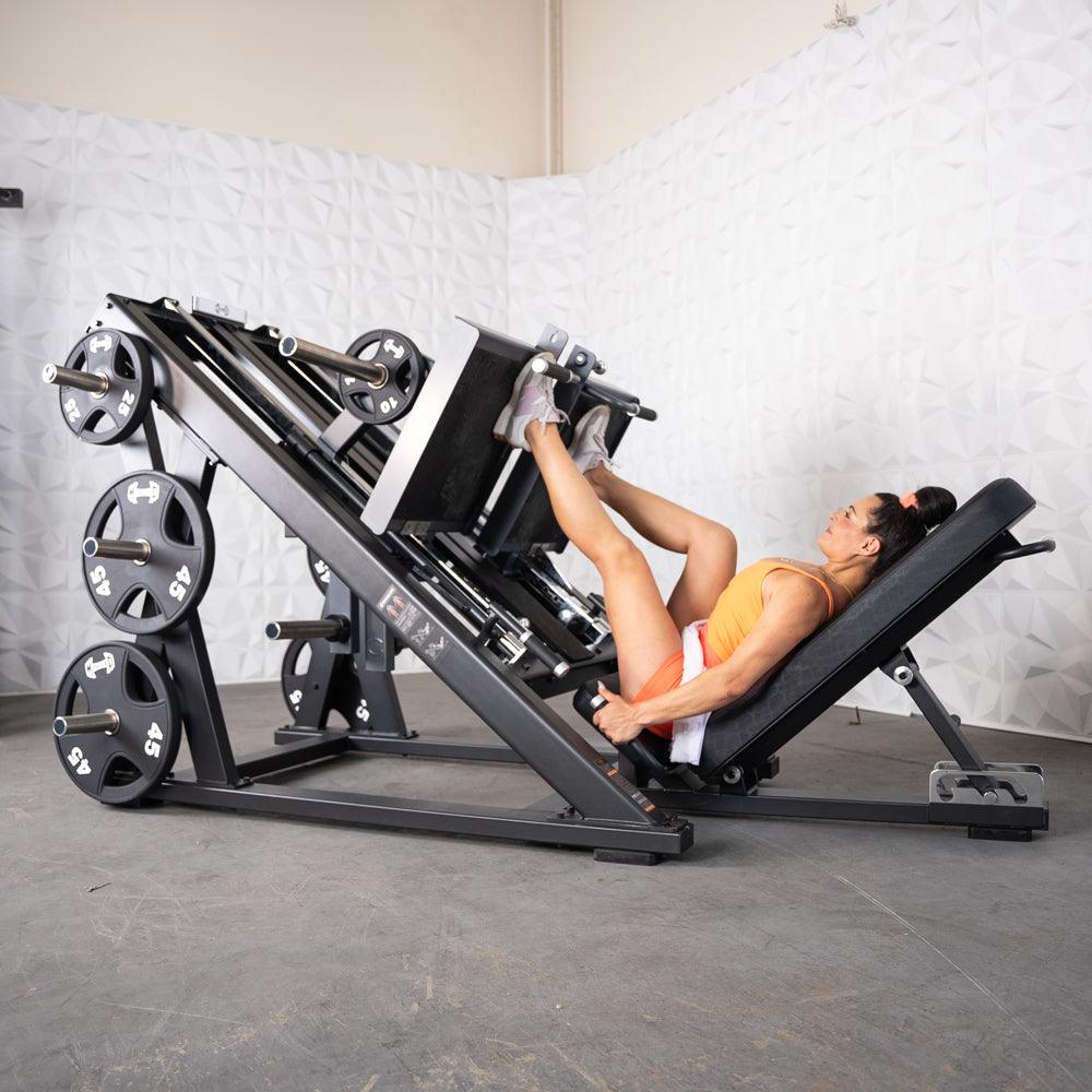 Person using ProStrength dual leg press machine in gym.