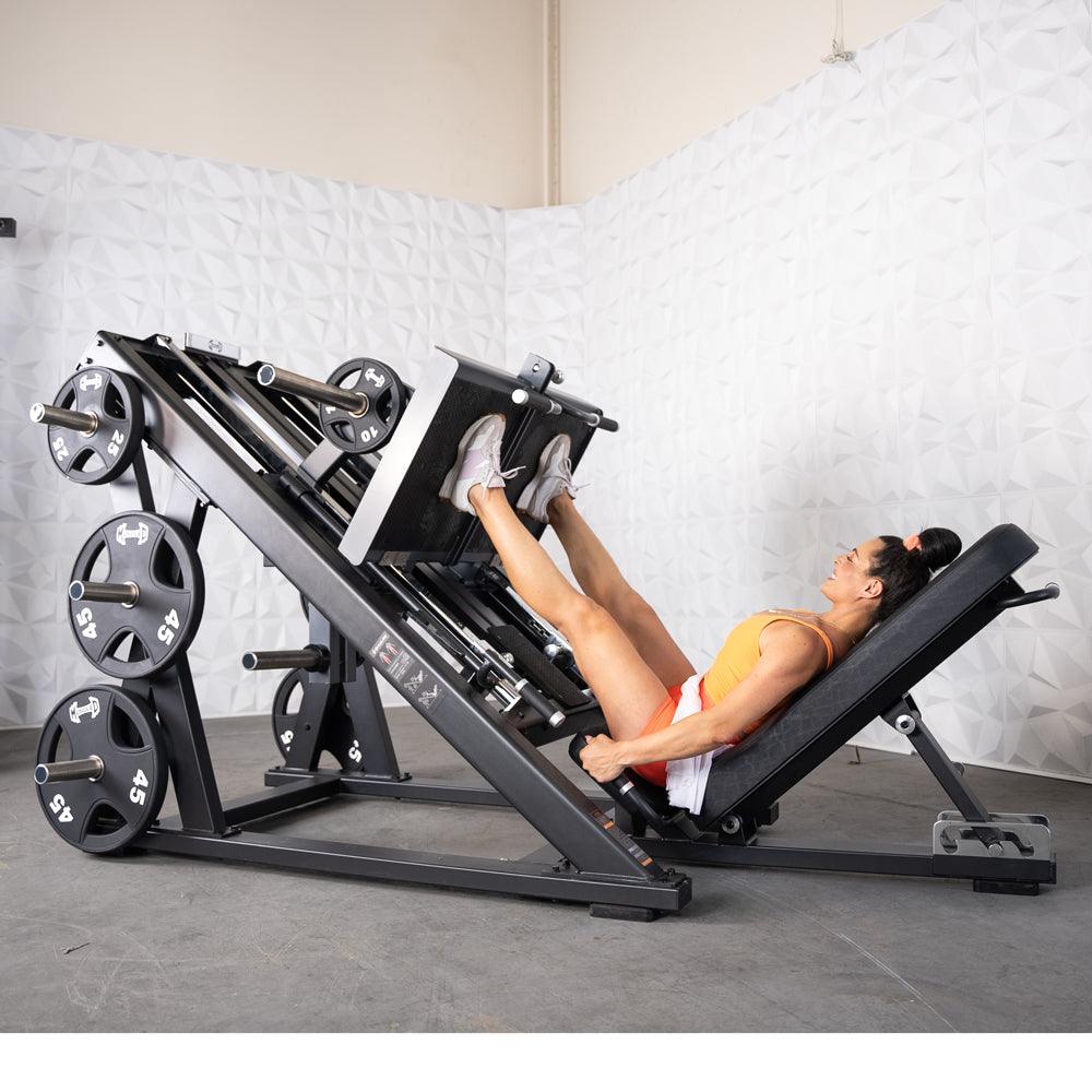 Woman using a ProStrength dual leg press machine in a gym.