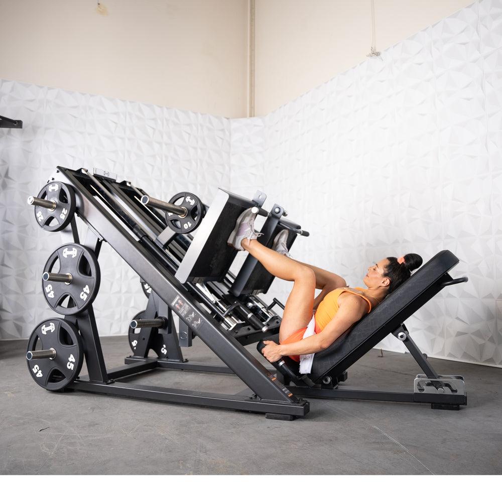 Woman using ProStrength dual leg press machine in gym.