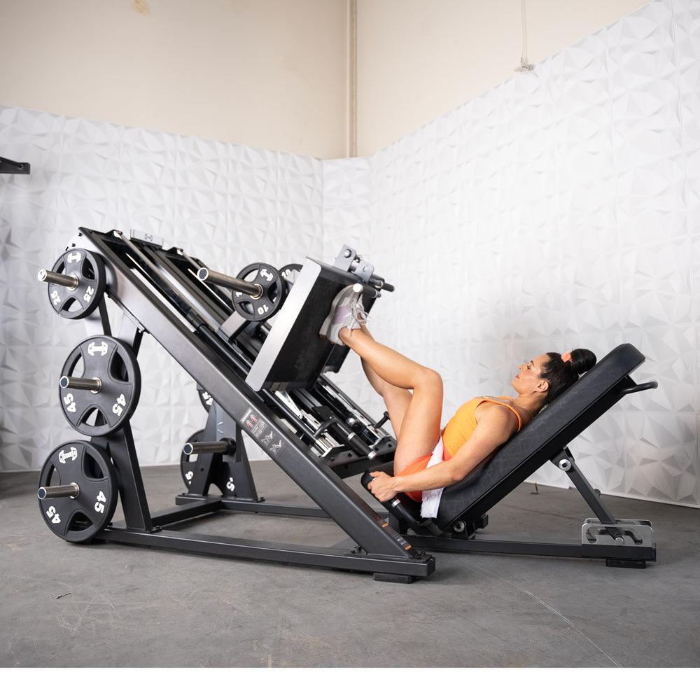 Woman using a ProStrength Dual Leg Press machine in gym.