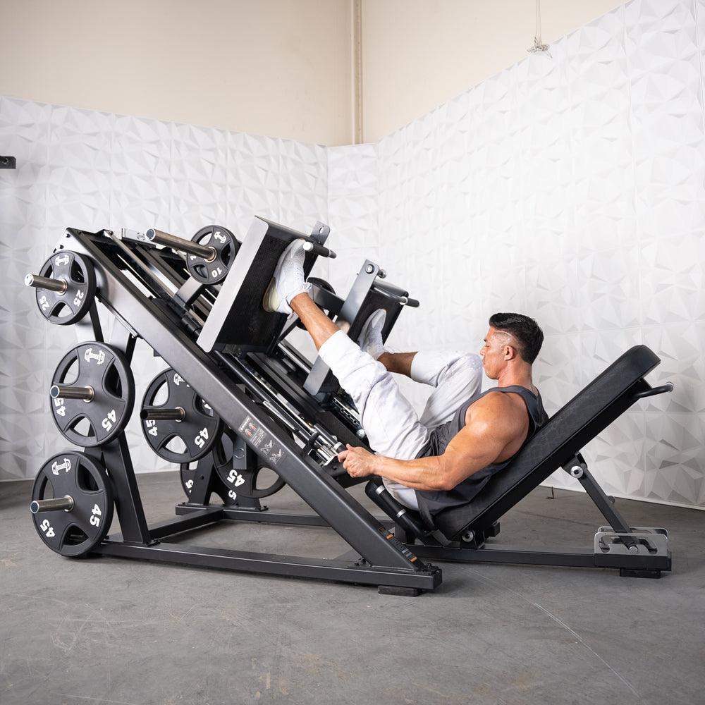 Man using ProStrength Dual Leg Press machine with weight plates in gym.