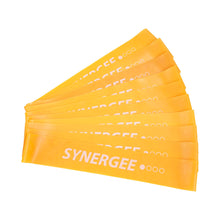 Stack of yellow fabric resistance bands labeled "Synergee" with varying resistance levels marked by dot indicators.