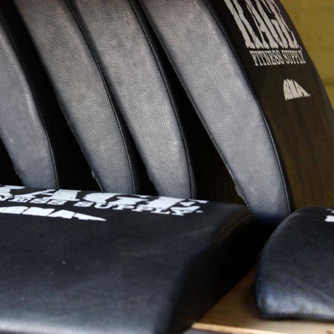 Gray and black weightlifting straps with 'Rage Fitness Supply' branding on a wooden surface.