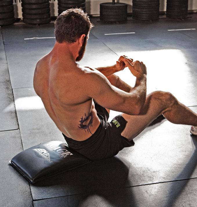 Man exercising on a mat in a gym setting