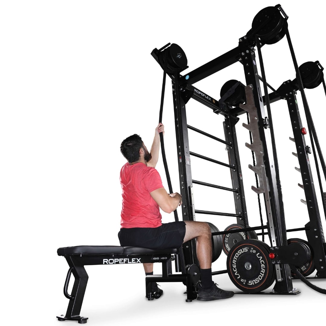 Man using Ropeflex exercise machine with black ropes in a gym setting.