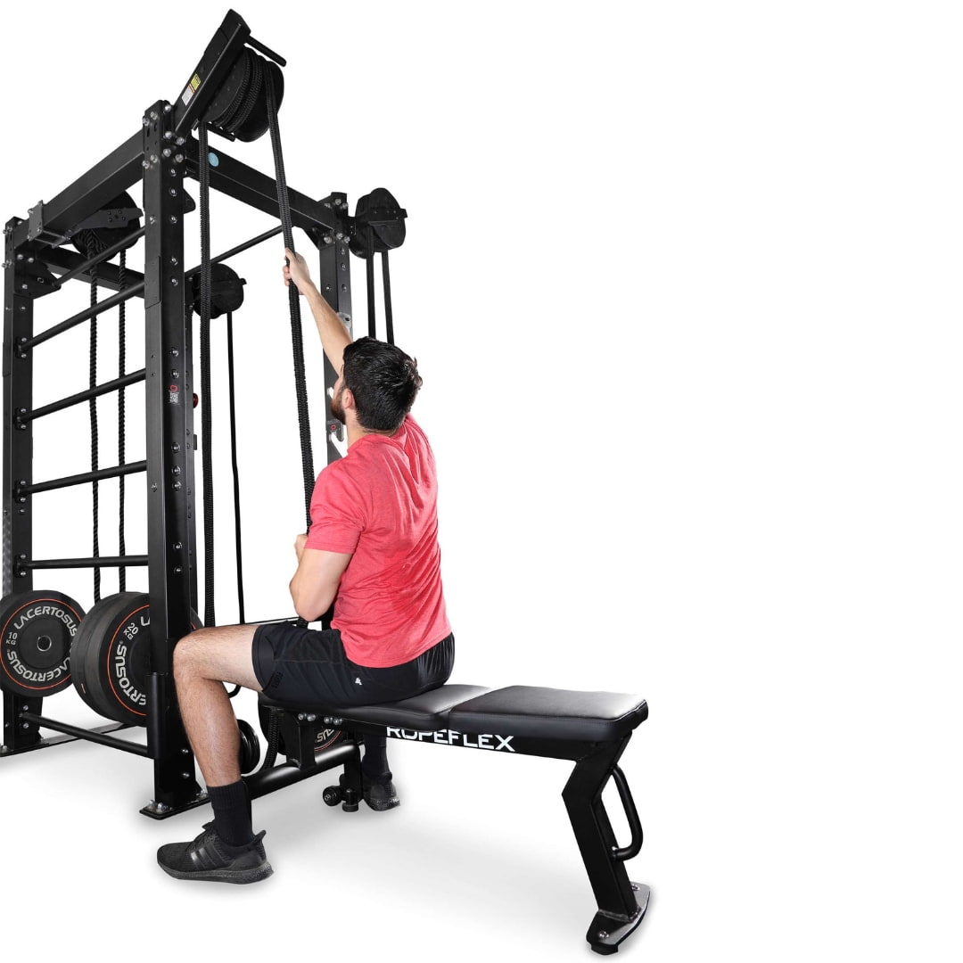 Man using ROPEFLEX rope machine with weights, wearing a red shirt.