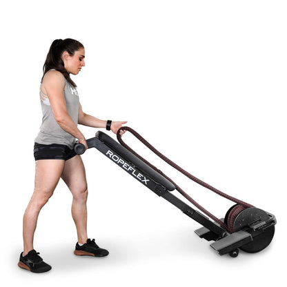 Woman using Ropeflex rope trainer, black, for upper body workout.