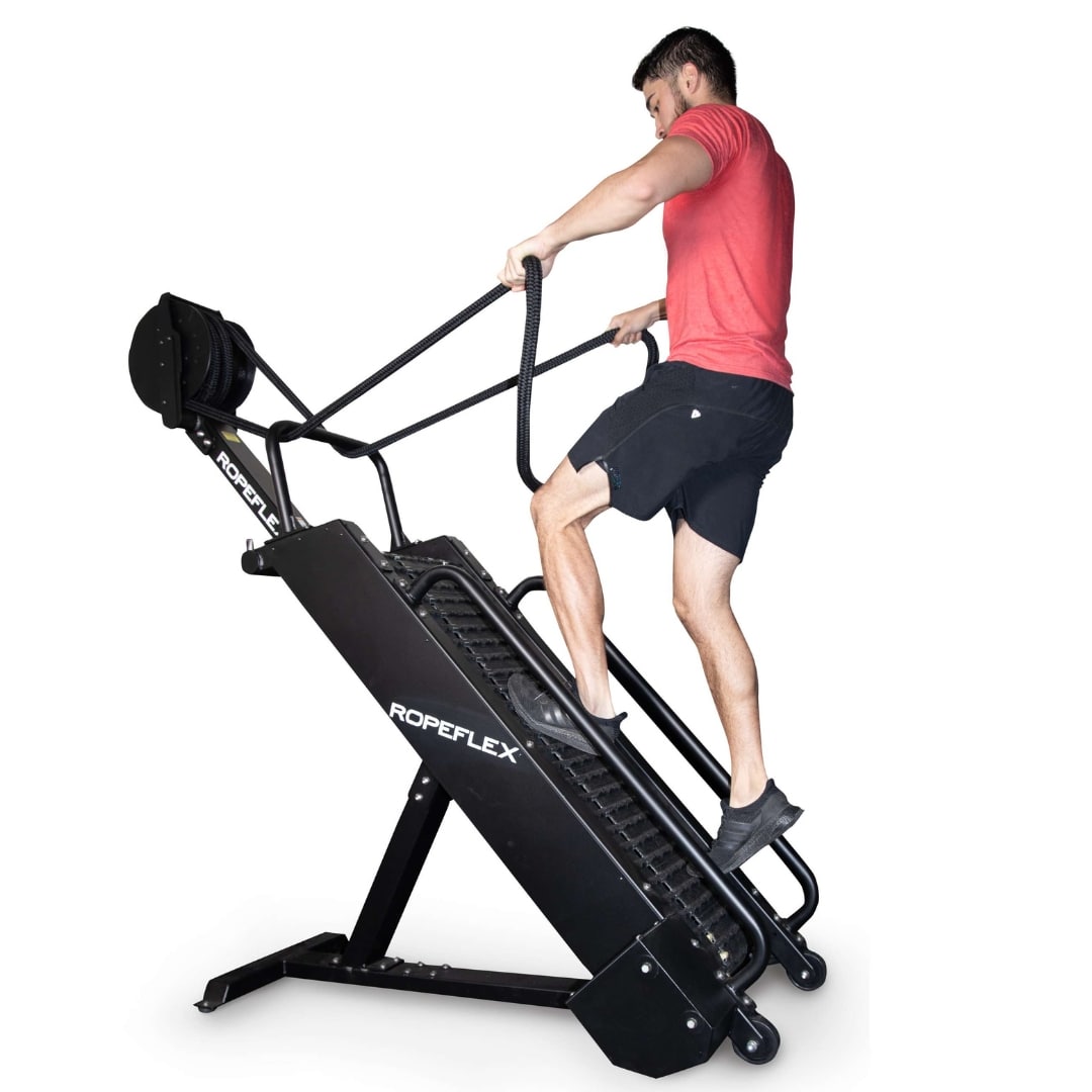 Man exercising on black ROPEFLEX RX2300 rope treadmill, wearing red shirt and black shorts.