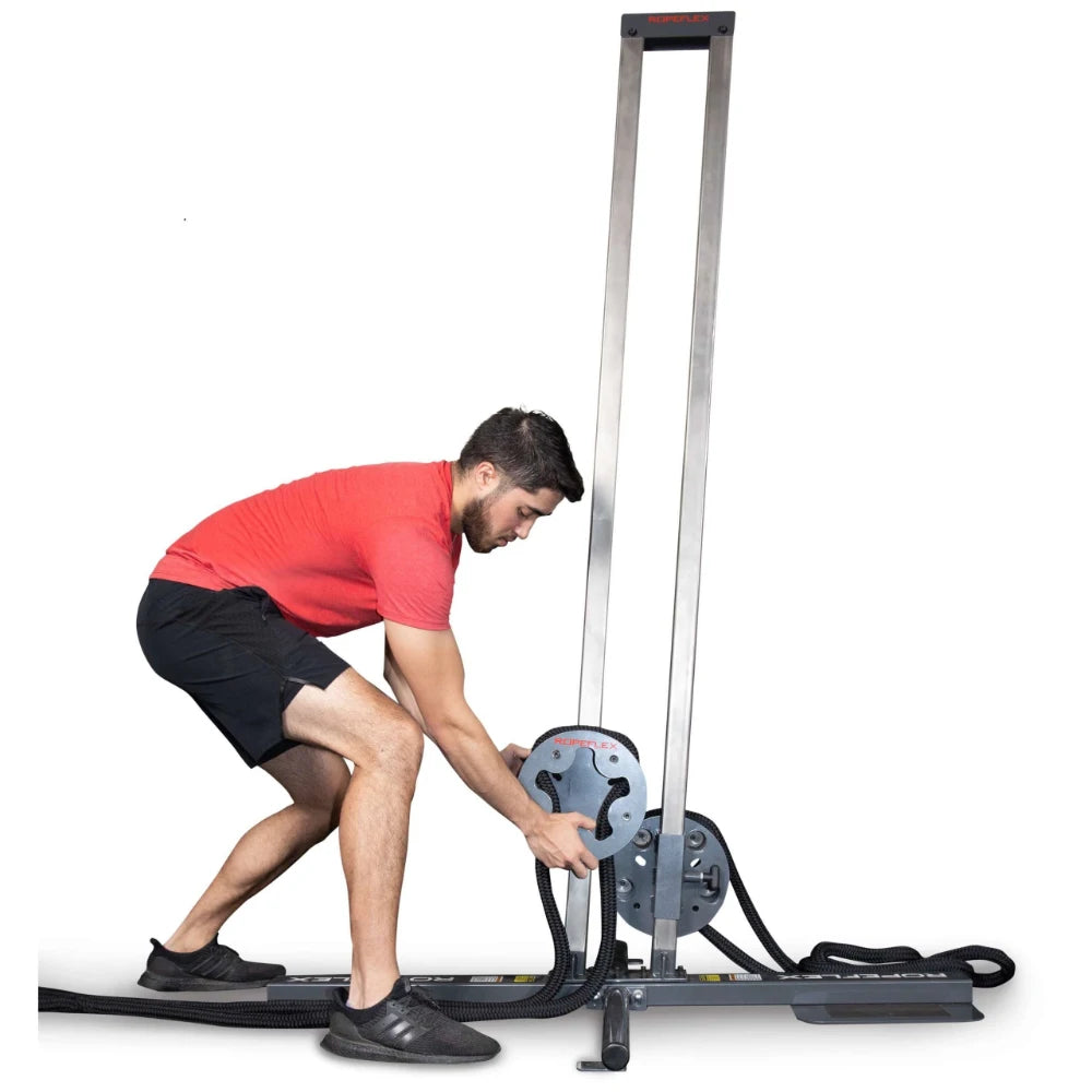 Man adjusting ropes on Keiser functional trainer, wearing red shirt and black shorts.