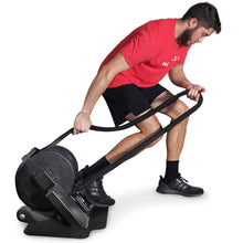 Man using Rogue Echo Bike in red shirt with black battle ropes for intense workout.