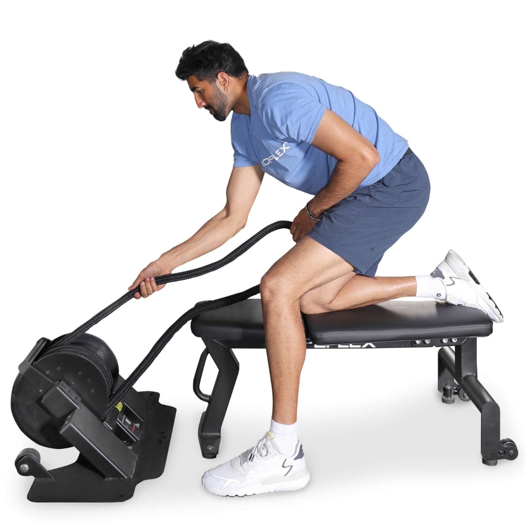 Man using Teeter Power10 elliptical rower wearing blue shirt and shorts.
