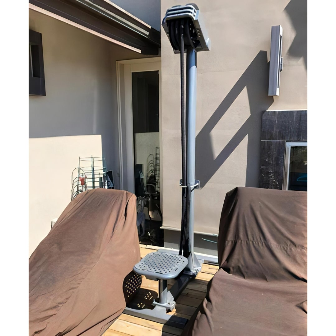 Outdoor clothesline with a retractable design on a patio, featuring a sleek gray finish.