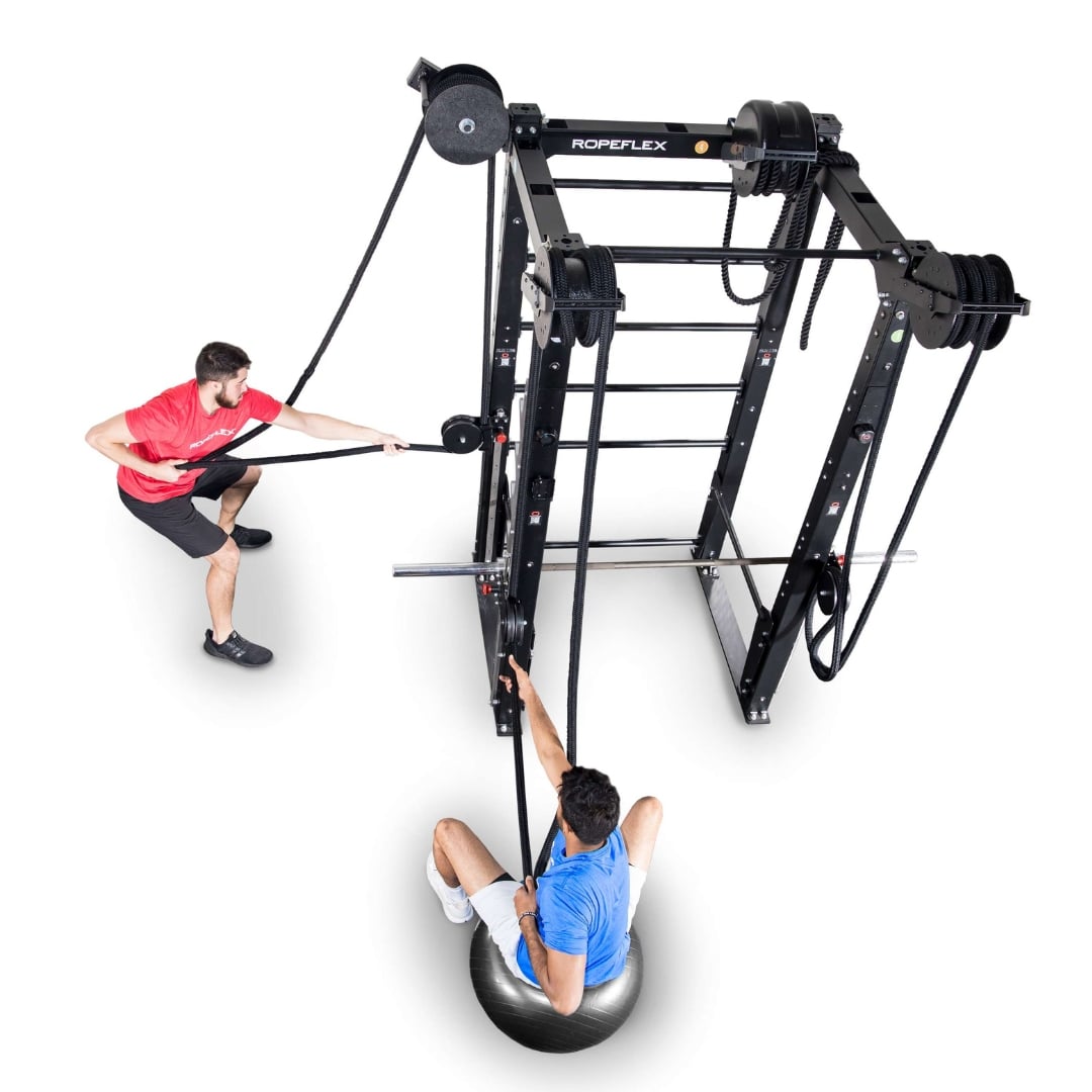 Ropeflex fitness equipment with two men exercising, featuring a pulley system and stability ball.