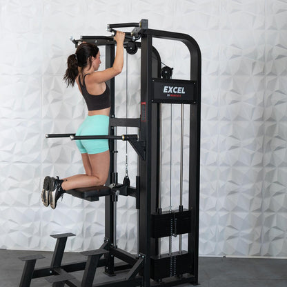 Woman using Excel pull-up machine in a gym, wearing teal shorts.