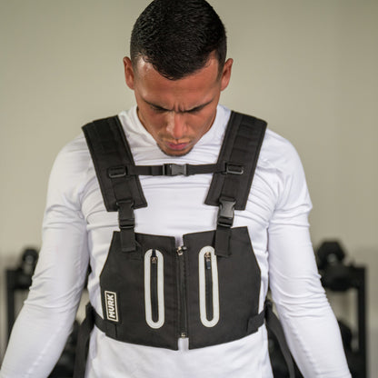 Man wearing a black weighted vest during a workout.
