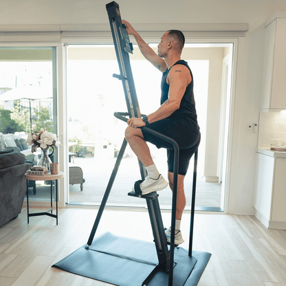 VersaClimber Home – athlete using vertical climber in modern living room lifestyle photo